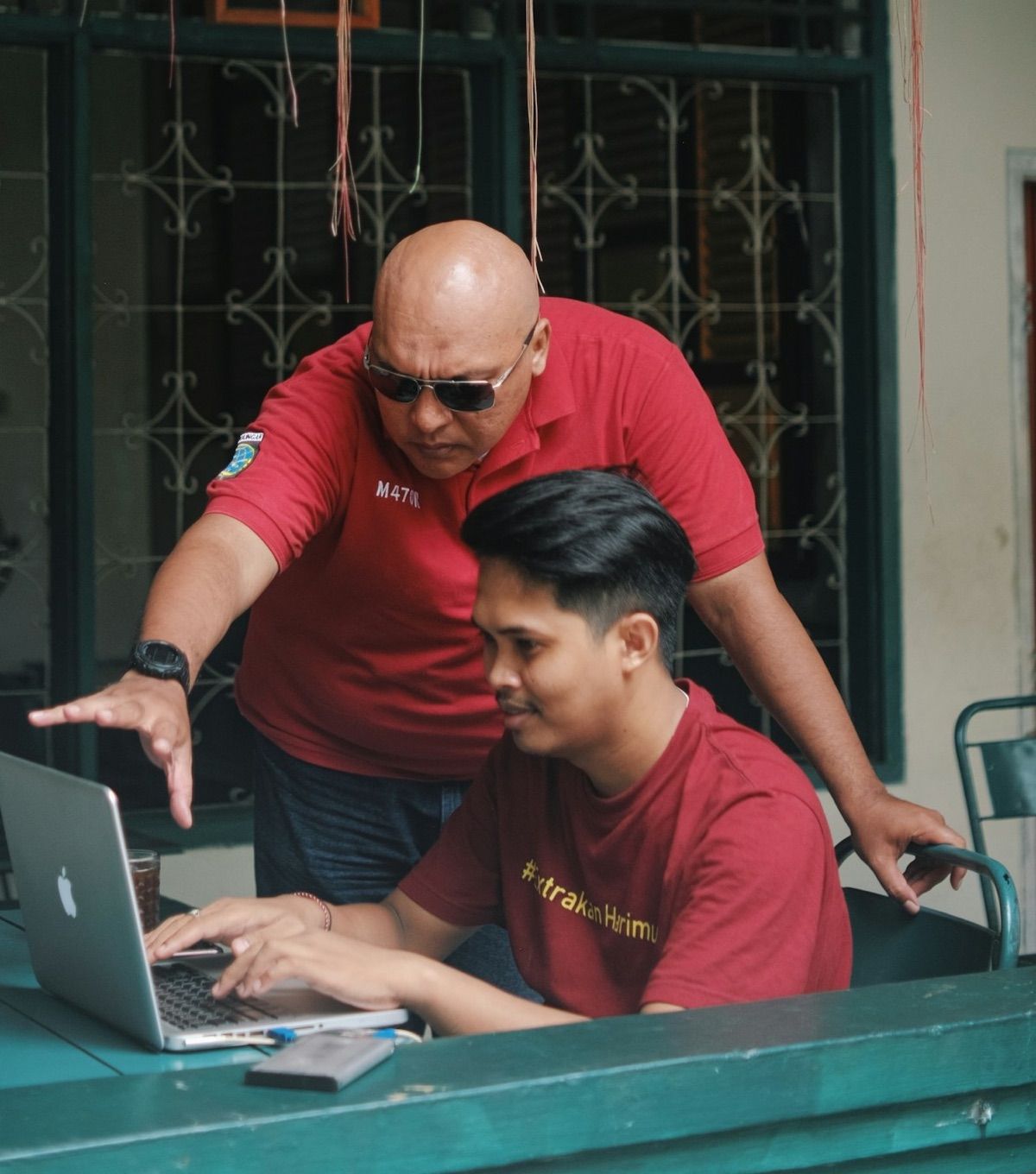 Dua orang berdiskusi di depan laptop